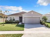 Charming single-story home features a well-maintained lawn, tidy landscaping, and a two-car garage at 993 Calico Pointe Cir, Groveland, FL 34736