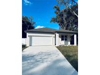 Charming single-story home featuring a clean white exterior, attached two-car garage, and well-lit driveway at 1015 25Th St, Orlando, FL 32805