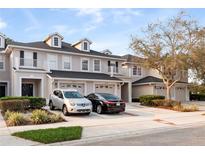 Beautiful two-story townhomes showcasing individual garages and private balconies under a serene sky at 1218 Falling Star Ln, Orlando, FL 32828