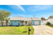 Charming single-story home featuring a well-manicured lawn and a driveway leading to an attached garage at 161 Laurel Way, Kissimmee, FL 34743