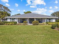 Charming one-story home with a well-manicured lawn, mature landscaping, and a welcoming front porch at 19 Meadowlake Ct, Winter Haven, FL 33884