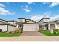 Charming two-story home featuring a brick driveway and a well-manicured front yard at 2242 Huntsman Ridge Rd, Clermont, FL 34715