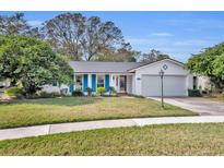 Charming single-story home featuring blue shutters, a well-manicured lawn, and attached two-car garage at 2642 Tierra Cir, Winter Park, FL 32792