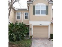 Charming townhome featuring a one car garage and well maintained front yard with mature landscaping at 6855 Sperone St, Orlando, FL 32819