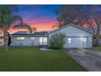 Charming single-story home featuring a lush green lawn and solar panels for energy efficiency at 9544 Brimton Dr, Orlando, FL 32817