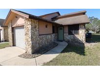 Charming home exterior features stone accents, a one car garage and a walkway to the front door at 1104 Southampton Dr # 3, Port Orange, FL 32129