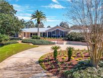 Stunning home featuring manicured landscaping, a circular driveway, and lush green lawn at 12104 Lakeshore Dr, Clermont, FL 34711