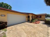 Inviting one-story home featuring an attached two-car garage and a well-maintained landscaped yard at 210 Dartmouth St, Deltona, FL 32725