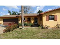 Charming single-story home featuring an arched entryway, colorful landscaping, and a one-car garage at 210 Dartmouth St, Deltona, FL 32725