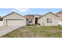 Charming single-story home with a two-car garage and well-maintained front lawn at 2537 Rock Pl, Poinciana, FL 34759