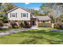 Charming two-story home featuring a brick and siding facade, lush landscaping, and a well-maintained front lawn at 259 Westchester Dr, Deland, FL 32724