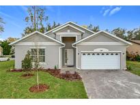 Charming home with a white garage door, gray siding, and a well manicured yard at 340 Bahia Cir, Longwood, FL 32750