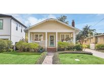 Charming home featuring a brick walkway, lush landscaping, and a welcoming front porch with flower boxes at 616 Sheridan Blvd, Orlando, FL 32804