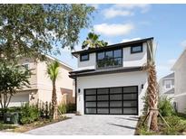 Modern two-story home featuring a black framed garage door and monochromatic color scheme at 7433 Excitement Dr, Reunion, FL 34747