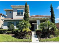 Two-story home with tile roof, manicured landscaping, and walkway to front entrance at 9406 Mere Pkwy, Orlando, FL 32832