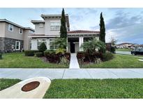 Charming two-story home featuring a beautiful front yard, manicured landscaping, and a tile roof at 9406 Mere Pkwy, Orlando, FL 32832