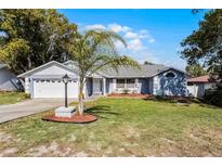 Charming single-story home with well-maintained lawn and landscaped garden featuring a young palm tree at 950 Sylvia Dr, Deltona, FL 32725