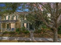 Charming townhome featuring lush landscaping, covered entry, and sidewalk at 14143 Ancilla Blvd, Windermere, FL 34786