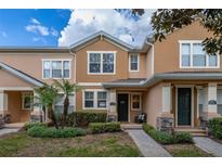 Charming townhome featuring manicured landscaping, a covered entry, and a welcoming facade at 14203 Avenue Of The Grvs, Winter Garden, FL 34787