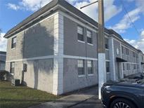 Two-story apartment building with gray stucco and white trim on a sunny day at 2761 L B Mcleod Rd # A, Orlando, FL 32805