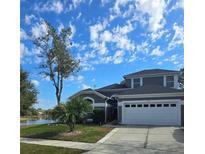 Charming two-story home features an attached garage, manicured lawn, and a scenic waterfront view at 318 Mohave Ter, Lake Mary, FL 32746