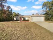 Charming single-story home features an attached two-car garage and a well-maintained front lawn at 3891 Sw 130Th Loop, Ocala, FL 34473