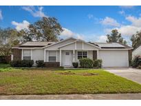 Charming single-story home featuring a well-maintained lawn, solar panels and an attached two car garage at 414 Tranquille Oaks Dr, Ocoee, FL 34761