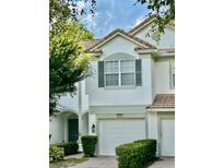 Charming townhome featuring a two-car garage, arched entryway, and well-maintained landscaping at 6912 Hochad Dr, Orlando, FL 32819