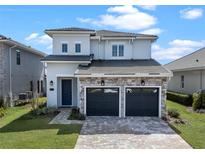 Beautiful two-story home featuring a stone facade, a two-car garage, and professionally landscaped front yard at 16112 Vetta Dr, Montverde, FL 34756