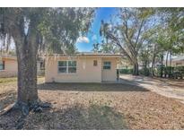 Quaint single-story home with mature trees creating a serene and inviting atmosphere at 203 North E Blvd, Davenport, FL 33837