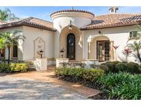 Elegant home exterior with a Mediterranean-style tower and meticulously manicured landscaping at 3412 Lilas Ct, Windermere, FL 34786