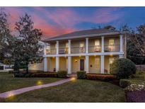 Stately two-story home featuring columns, a landscaped yard, and a brick walkway at 450 Lakewood Dr, Winter Park, FL 32789