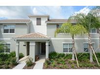 Inviting townhome exterior with well-maintained landscaping and covered front porch entry at 4879 Clock Tower Dr, Kissimmee, FL 34746