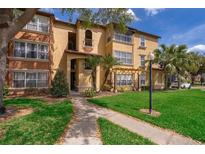 Well-maintained condo building with lush landscaping, sidewalk, and palm trees on a sunny day at 5120 Conroy Rd # 513, Orlando, FL 32811
