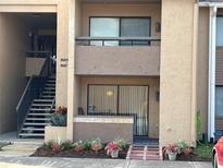 Inviting exterior featuring a second story balcony and lush landscaping at 5201 Vineland Rd # 112, Orlando, FL 32811
