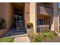Exterior view of a building featuring stairs leading to the upper levels and landscaped plants at 5201 Vineland Rd # 112, Orlando, FL 32811