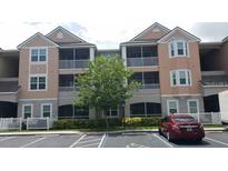 Exterior view of condo building featuring screened patios, and accessible parking in front at 6412 Queens Borough Ave # 109, Orlando, FL 32835