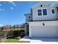 Two-story home features a white garage door, blue siding, and nicely manicured landscaping at 645 Astera Winds Ln, Lake Mary, FL 32746