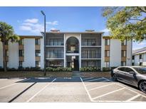 Condo building featuring multiple units with screened balconies and well-maintained landscaping at 8215 Sun Spring Cir # 32, Orlando, FL 32825