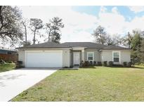 Attractive single-story home with a garage, a manicured lawn, and mature landscaping at 1090 Parnell Ct, Deltona, FL 32738