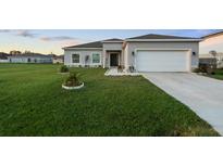 Charming single-story home featuring a well-manicured lawn, two-car garage, and welcoming front entrance at 196 Anzio Dr, Kissimmee, FL 34758