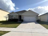 Charming single-Gathering home featuring a well-manicured lawn and attached two-car garage at 2877 Sunridge Loop, St Cloud, FL 34771