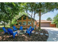 Charming home featuring a lovely front yard with a fire pit and Adirondack chairs at 2929 Lakeshore Dr, Mount Dora, FL 32757