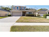 Charming two-story home with well-manicured lawn and a brick driveway at 34429 Alameda Dr, Sorrento, FL 32776