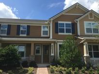 Charming townhome with manicured landscaping, inviting front porch, and neutral colors at 8476 Iron Mountain Trail, Windermere, FL 34786