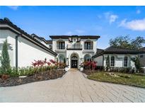 Elegant two-story home featuring black and white accents, beautiful landscaping, and a paved driveway at 3037 Seigneury Dr, Windermere, FL 34786