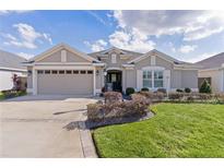 Charming single-story home featuring a well-manicured lawn, a two-car garage, and elegant landscaping at 3202 Condrey Ct, The Villages, FL 32163