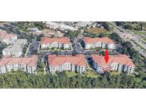 Aerial view of condo complex with terra cotta roofs and lush greenery at 4000 Breakview Dr # C207, Orlando, FL 32819