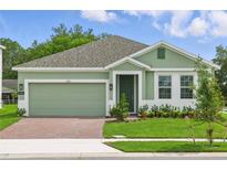 Charming single-story home featuring a brick driveway, green grass, and a cozy entrance at 5960 Vision Rd, St Cloud, FL 34771