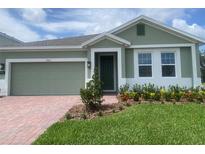 Inviting home featuring a brick driveway, manicured lawn, and tasteful landscaping at 5960 Vision Rd, St Cloud, FL 34771